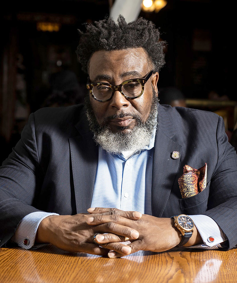 man in blue white and red plaid button up shirt wearing yellow hard hat holding black